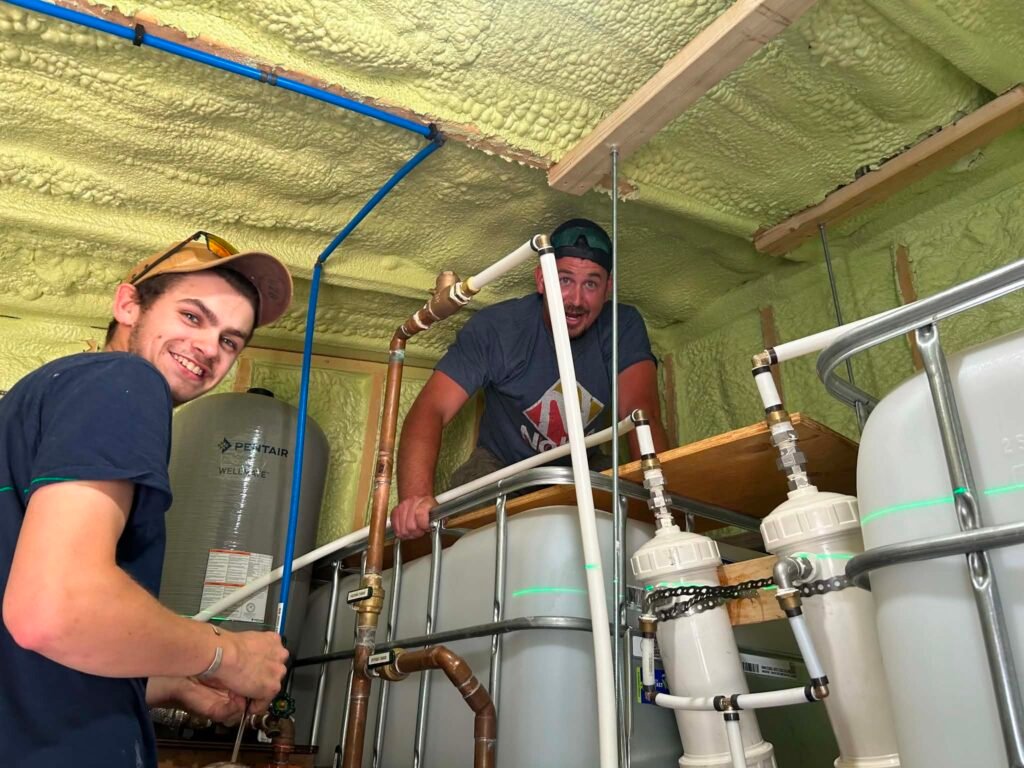 613 Plumbing technicians installing a water filtration and pressure tank system in an Ottawa home