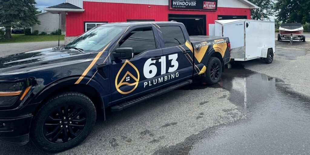 613 Plumbing truck and trailer parked outside the Wendover service station